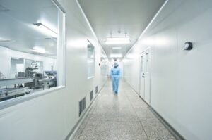 person walking down hallway with clean rooms on each side